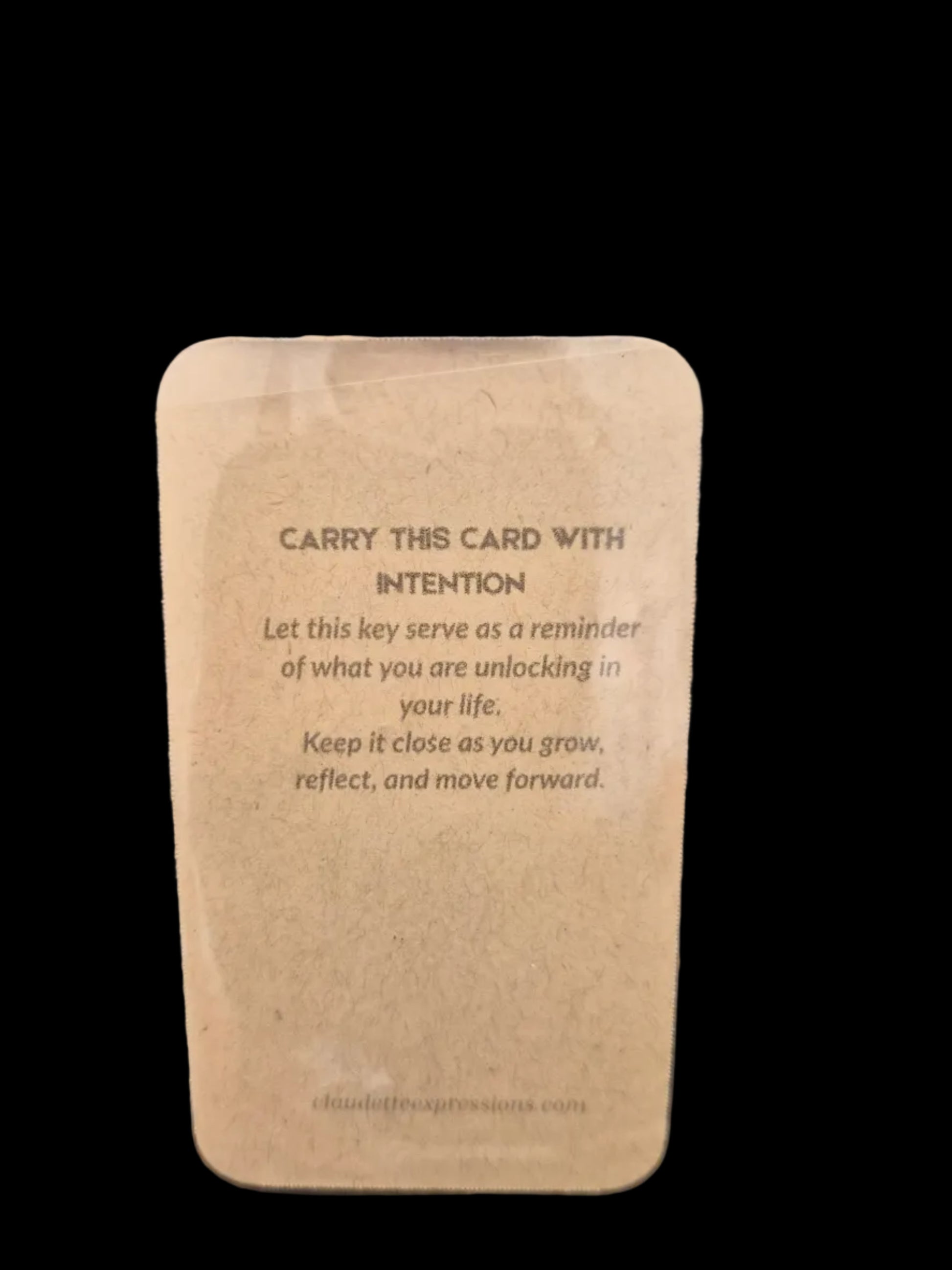 Brown card with text on a clear plastic sheet over a dark surface
