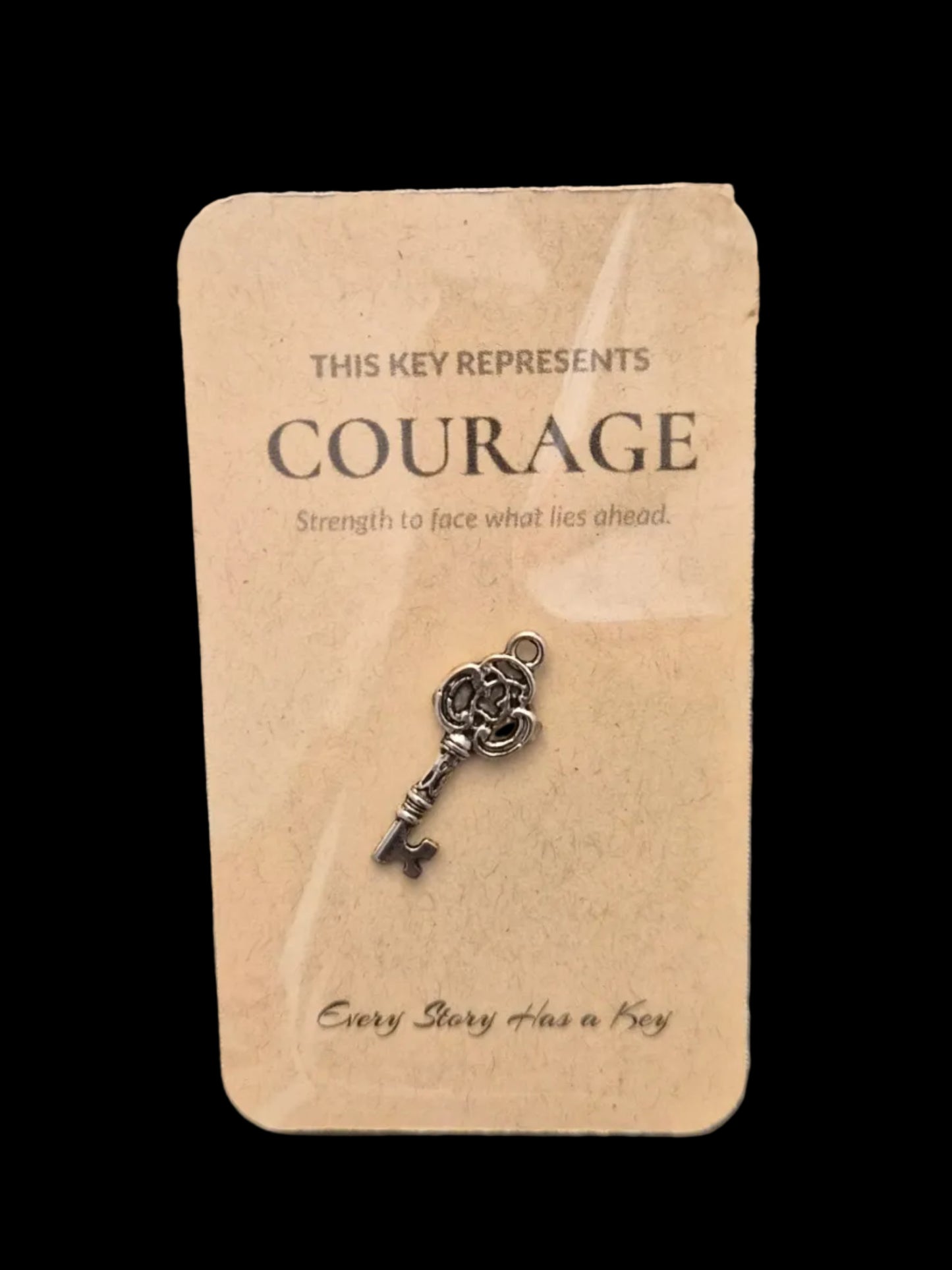 Decorative key on a card labeled 'Courage' on a dark wooden surface
